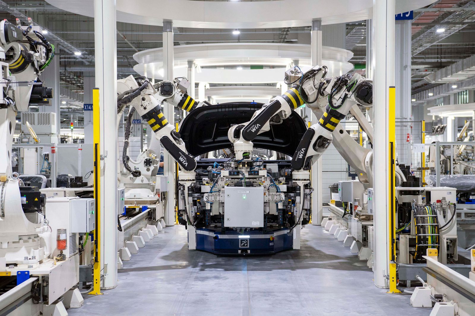 Electric vehicle assembly line with robotic arms