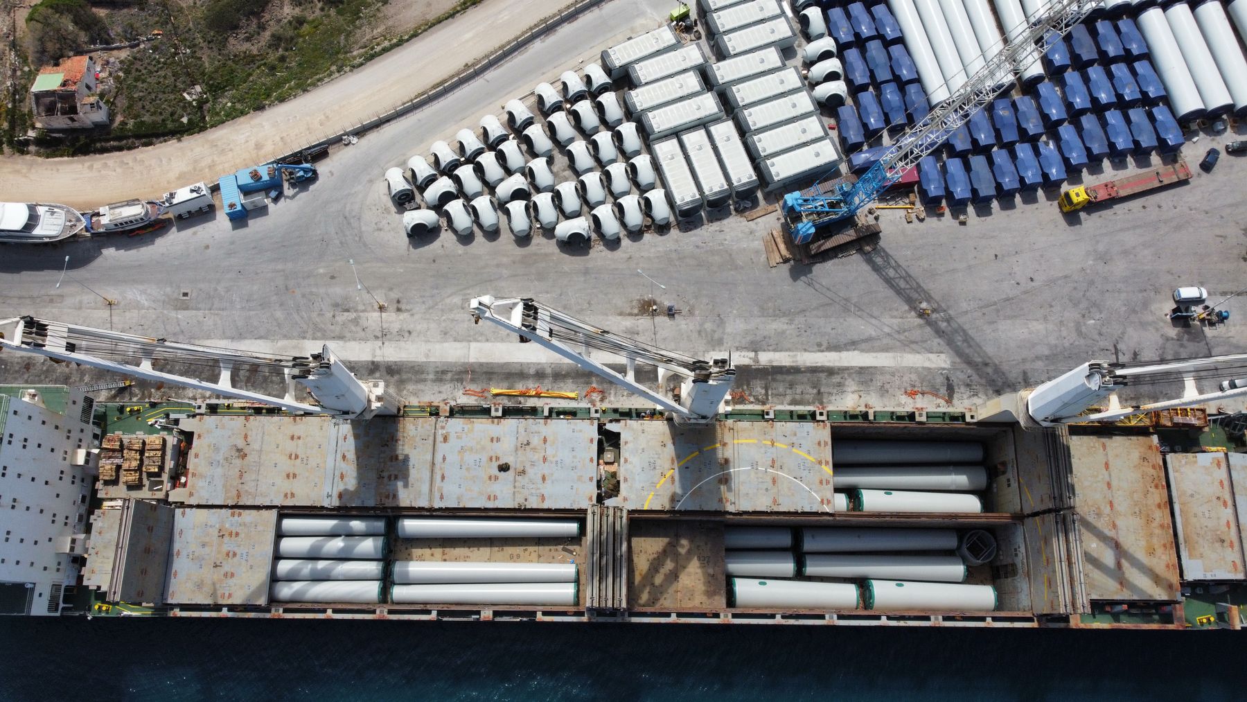 Wind-energy tower sections loaded as breakbulk by quay cranes